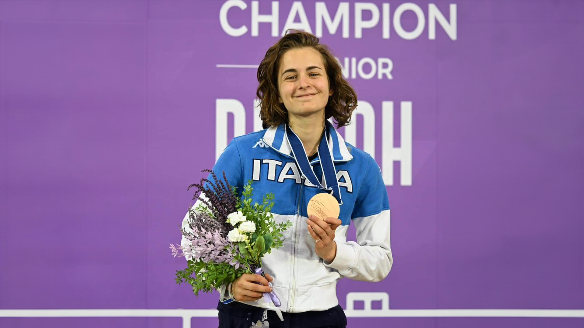 Anita corradino sul palco che tiene la medaglia