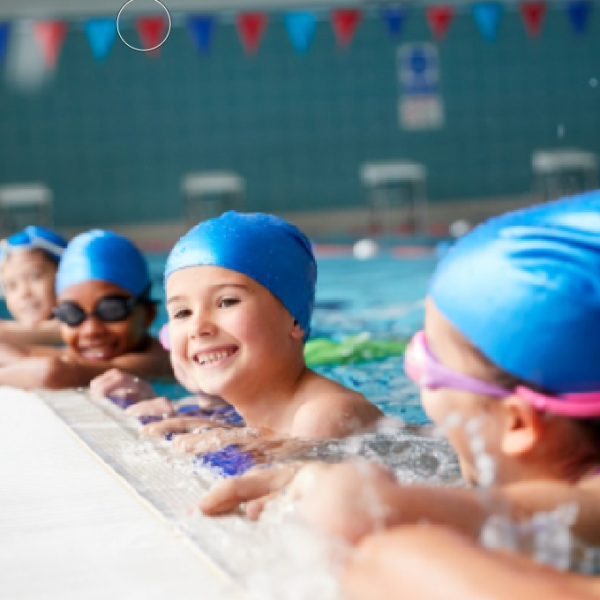 Un gruppo di bambini che indossano cuffie e occhialini da nuoto.