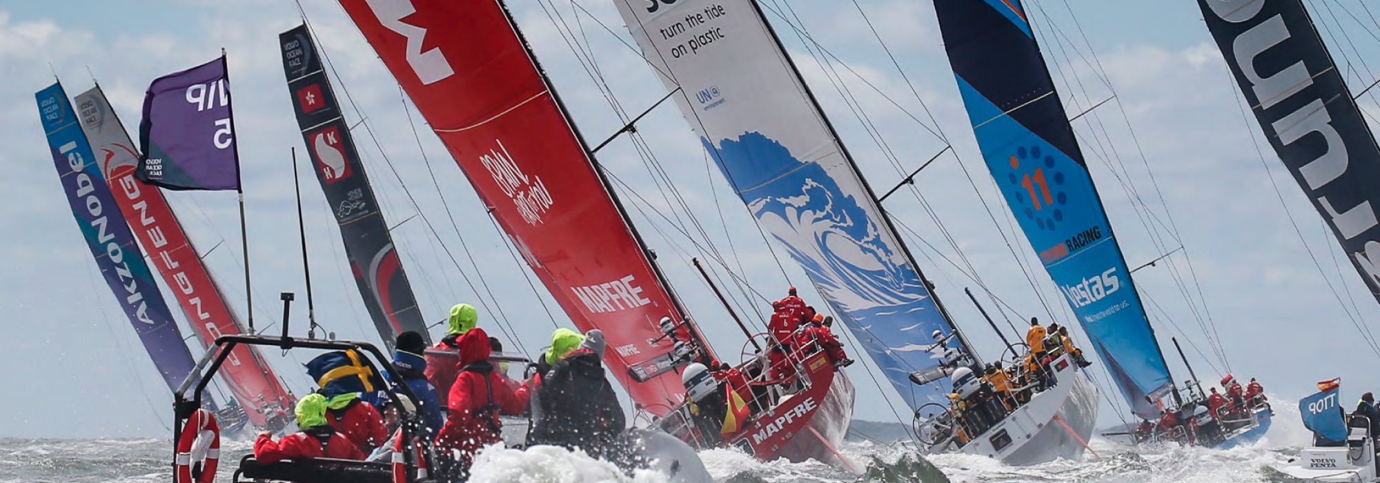 Una flotta di barche a vela impegnate in una regata competitiva, scivolano con grazia attraverso la vasta distesa dell'oceano.